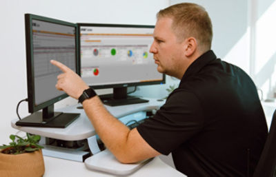 Operatore che indica il monitor di un computer che mostra le schermate di gestione di LIFENET Asset